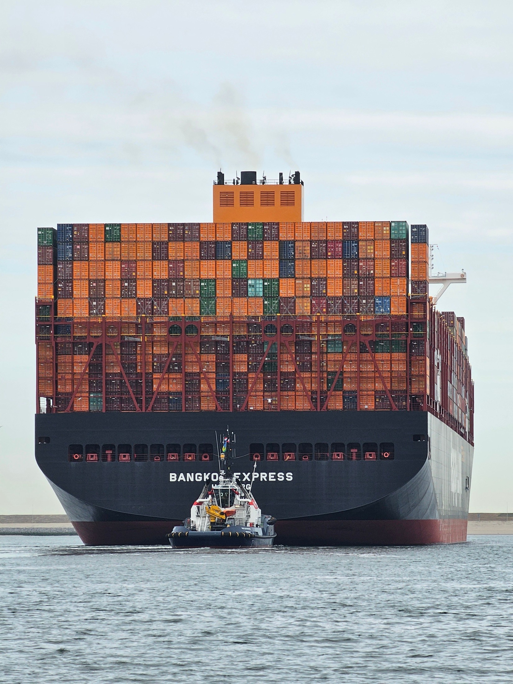 Large container vessel assisted by tug